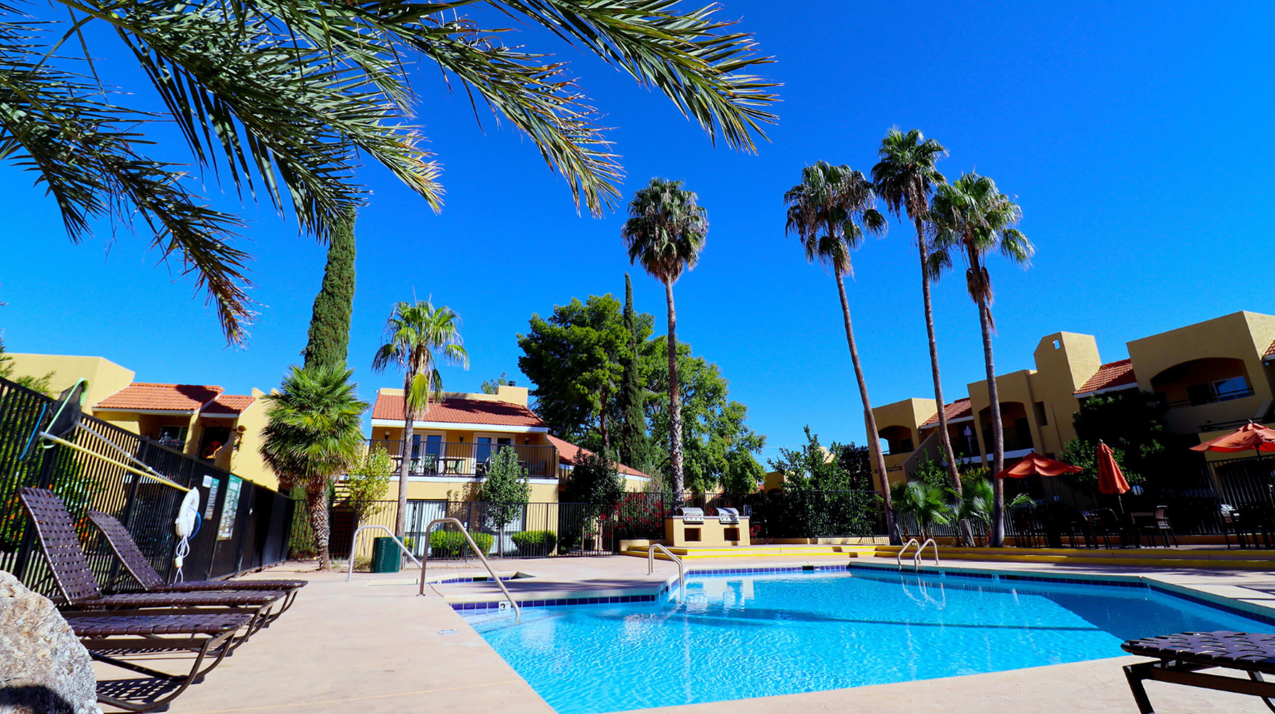 Exterior of an apartment building with dog park and tables