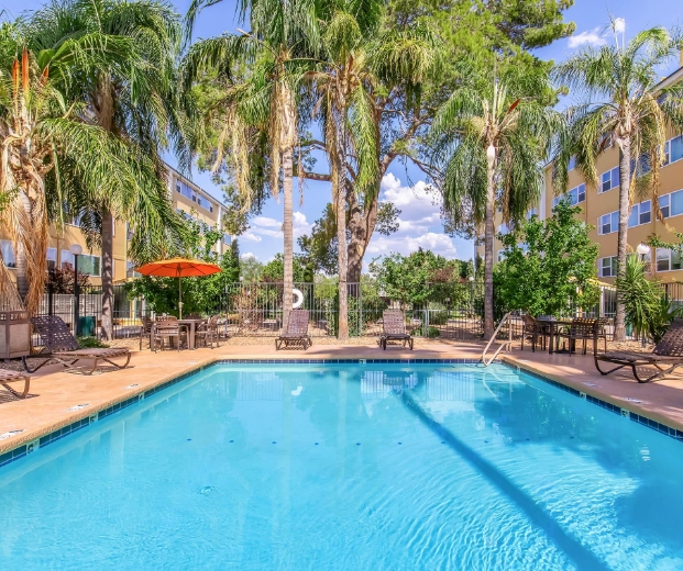Four adults standing around barbecue with food
